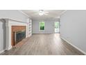 Open-concept living room with a brick fireplace and hardwood flooring throughout at 3 Cobble Glen Ct, Durham, NC 27713