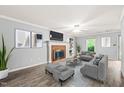 Cozy living room with a brick fireplace, neutral gray walls, and hardwood flooring at 3 Cobble Glen Ct, Durham, NC 27713