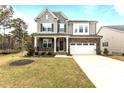 Charming two-story home with gray siding, stone accents, two-car garage, and meticulously kept front yard at 3020 Mavisbank Cir, Apex, NC 27502