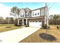 Beautiful two-story home featuring stone accents, gray siding, a two-car garage, and a meticulously kept lawn at 3020 Mavisbank Cir, Apex, NC 27502