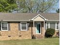 Charming brick home featuring a welcoming turquoise front door and well-maintained landscaping at 305 Briarcliff Dr, Dunn, NC 28334