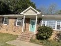 Charming brick home featuring a welcoming turquoise front door and well-maintained landscaping at 305 Briarcliff Dr, Dunn, NC 28334