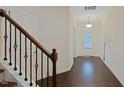 Inviting foyer with hardwood floors, staircase, and decorative tree art on the wall at 317 Springhurst Ln, Cary, NC 27511