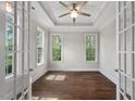 Sunlit office with tray ceiling, hardwood floors, and glass French doors with natural light at 344 Colonial Ridge Dr, Pittsboro, NC 27312