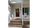 Inviting front porch with brick steps and a charming rocking chair at 352 Riverstone Dr, Clayton, NC 27527