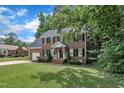 Charming two-story brick home featuring black shutters, attached garage, and well-kept lawn at 418 Old Scarborough Ln, Garner, NC 27529