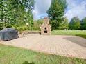 Expansive backyard with brick patio and stone fireplace great for entertaining or relaxing at 4200 Harmony Church Rd, Efland, NC 27243
