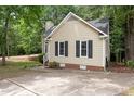 A well-maintained home featuring a concrete driveway, a brick foundation, and neutral siding at 4401 Liverpool Ln, Raleigh, NC 27604