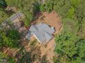 Aerial view of a home, showcasing its architectural design, backyard, and surrounding wooded landscape at 5163 S River Rd, Lillington, NC 27546