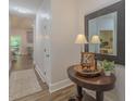 Welcoming entryway with wood floors, decorative mirror, table, and stylish accents at 5163 S River Rd, Lillington, NC 27546