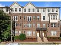 Attractive brick townhome with a covered entryway, manicured landscaping, and gray shingle siding on the upper floors at 531 N Person St # 205, Raleigh, NC 27604