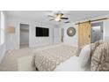 Bright main bedroom boasts a ceiling fan, TV, barn door and decorative mirror at 531 N Person St # 205, Raleigh, NC 27604
