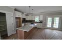 Modern kitchen featuring an island, stainless appliances, white cabinets, and a window view at 55 Stream View Way, Spring Hope, NC 27882
