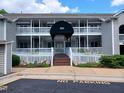 Charming condo building with covered entrance, white picket fence, and lush landscaping at 631 Springfork Dr, Cary, NC 27513