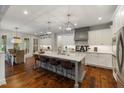 Spacious kitchen with white cabinets, gray island, stone countertops, and stainless-steel appliances at 6500 Bass Mountain Rd, Snow Camp, NC 27349