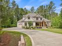 Spacious home displaying a long driveway leading to an attached garage, surrounded by lush greenery at 67 Spring Hollow Ct, Pittsboro, NC 27312