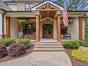 Inviting front porch with brick accents, wooden columns, and seating, perfect for relaxing outdoors at 67 Spring Hollow Ct, Pittsboro, NC 27312