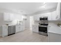 Bright kitchen with white cabinets, stainless steel appliances, and a modern backsplash at 7216 Carlton Dr, Raleigh, NC 27616