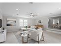 Inviting living room with large windows, light hardwood floors, and stylish neutral decor at 7216 Carlton Dr, Raleigh, NC 27616