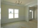 Bright living room features decorative molding, large window and chandelier at 788 Shade Tree Rd, Benson, NC 27504