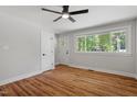 Light-filled bedroom featuring hardwood floors, a ceiling fan, and a view to the outdoors at 833 Brigham Rd, Raleigh, NC 27610