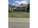 Two-story home featuring a brick exterior and a red metal roof at 836 S Main St, Roxboro, NC 27573