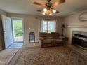 Cozy living room featuring a decorative rug, fireplace, and a comfortable reclining sofa at 8405 Falcon Crest Cir, Angier, NC 27501
