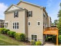 Rear view showing vinyl siding and deck area with greenery, offering a peaceful outdoor space at 100 Stratford Lakes Dr # 270, Durham, NC 27713