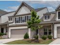 Two-story townhome showcasing a covered brick front porch with a two-car garage at 107 Explorer Dr, Morrisville, NC 27560