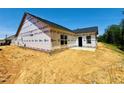 Side view of an unfinished new construction home with protective wrap, situated on a spacious lot at 1087 Fairhaven Dr # 48, Mebane, NC 27302