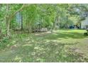Large backyard with mature trees and a grassy area perfect for outdoor activities at 109 Grange Dr, Wendell, NC 27591