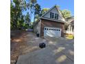 View of long concrete driveway leading up to the attached two-car garage of this brick house at 119 Comanche Dr, Louisburg, NC 27549