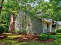 Well-maintained exterior with a brick chimney and lush landscaping at 119 Long Shadow Ln, Cary, NC 27518