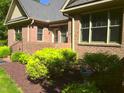 Brick facade with professionally landscaped flower beds and mature shrubbery in the front yard at 12 Crail Ct, Durham, NC 27712