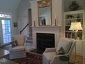 Traditional living room with fireplace and built-in shelving and area rug at 12 Crail Ct, Durham, NC 27712