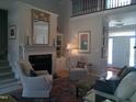 Elegant living room featuring a fireplace, soaring ceilings, and a view of the entryway at 12 Crail Ct, Durham, NC 27712