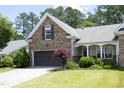 Beautiful home featuring stone accents, a two-car garage, and a well-manicured lawn and shrubs at 120 Jennel Way, Durham, NC 27707