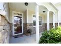 Inviting front porch with decorative columns, stone accents, flower pot and front door at 120 Jennel Way, Durham, NC 27707