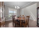 Bright dining room showcasing hardwood floors, elegant lighting, and ample seating at 137 Campaign Dr, Mebane, NC 27302