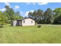 Spacious backyard with green lawn, utility shed, and a tree line in the background at 1512 Bacon St, Durham, NC 27701