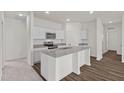 Modern kitchen featuring white cabinets, granite countertops, stainless steel appliances, and a functional island at 157 Gladstone Loop Dr, Clayton, NC 27520