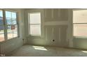 Bright, unfinished bedroom featuring three large windows allowing for ample natural light at 1613 Malcus Ct # 68, Fuquay Varina, NC 27526
