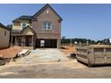 New construction brick home featuring an open two-car garage and craftsman architectural details at 1613 Malcus Ct # 68, Fuquay Varina, NC 27526
