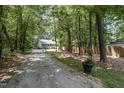 Home with a long driveway and fenced in yard, surrounded by lush trees at 2007 Eastwood Dr, Durham, NC 27703