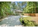 Quaint home with a long driveway and fenced in yard, surrounded by lush trees at 2007 Eastwood Dr, Durham, NC 27703