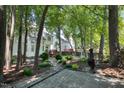 Private backyard with mature trees, a patio, and a view of the home's exterior at 203 Halls Mill Dr, Cary, NC 27519