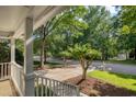 Inviting covered front porch with view of the street and mature trees at 203 Halls Mill Dr, Cary, NC 27519