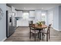 Bright kitchen with white cabinets, modern appliances, and an adjacent dining area with a round table at 222 Rosewood Dr, Sanford, NC 27330