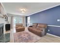 Living room featuring hardwood floors, fireplace, and neutral-toned furniture at 2312 Brasswynd Ct, Fuquay Varina, NC 27526
