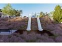 Community playground featuring slides, surrounded by natural landscaping and offering recreational space at 259 Meadowbark Bnd # 32, Garner, NC 27529